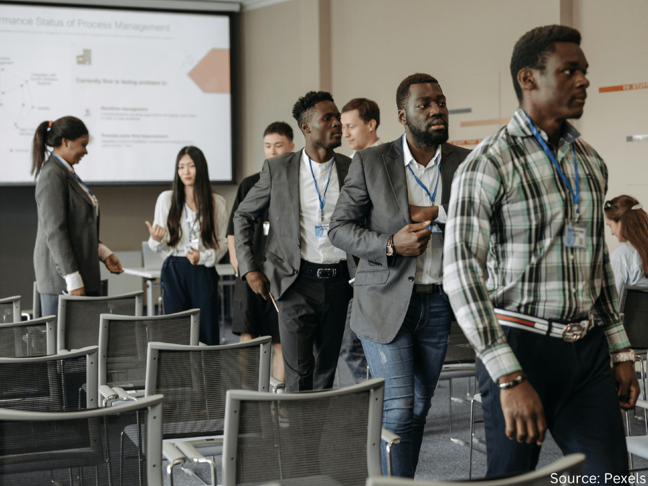 a group of people walking out of a seminar room